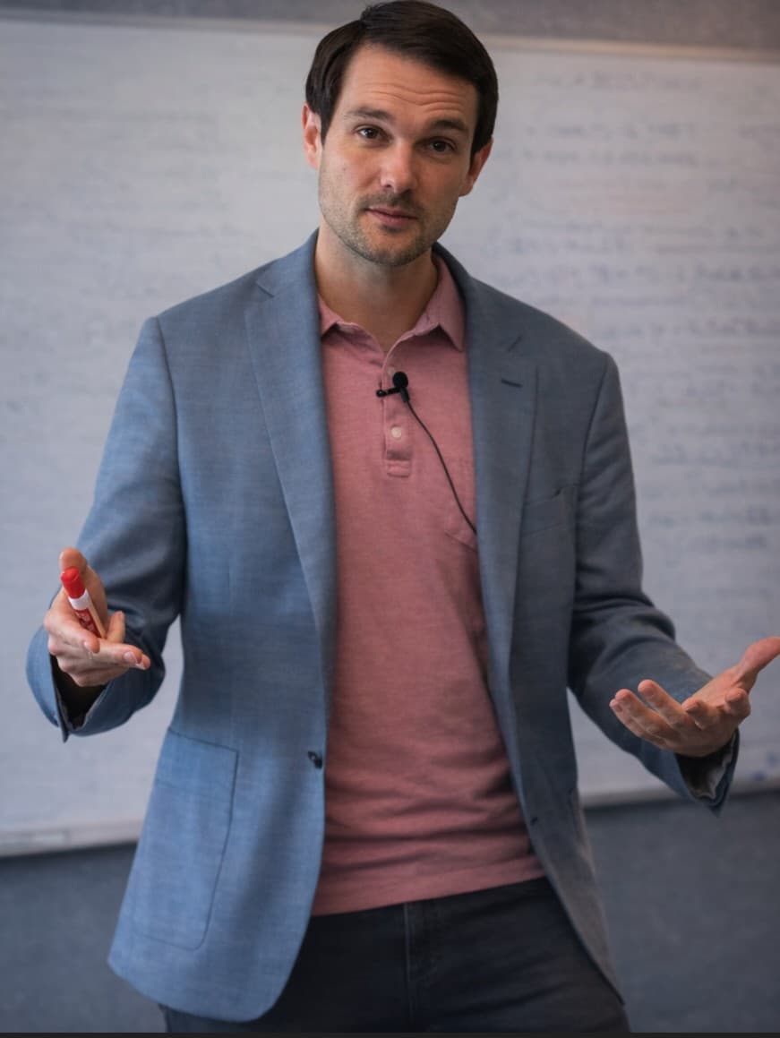Devon Coombs teaching finance at a whiteboard